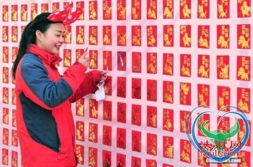 资料图：2018年2月16日，大年初一，游客来到天津方特欢乐世界红包墙前抢包红。中新社记者 佟郁 摄